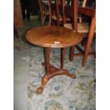 A small walnut occasional table of circular form with moulded outline raised on three slender ring