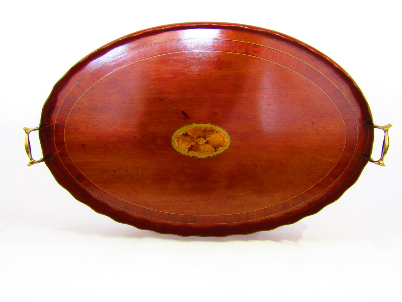 An oval Georgian mahogany serving tray with wavy edge border and inlaid detail