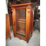 A late Victorian walnut music cabinet enclosed by a full length rectangular glazed panelled door