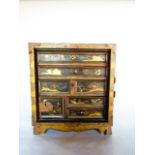 A late 19th/early 20th century Japanese lacquered cabinet of squared form housing an assortment of