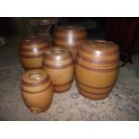 Five vintage treacle glazed stoneware barrels of graduated size with banded detail