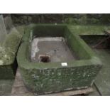 A natural stone garden trough of rectangular form, thickly walled with rounded front corners (