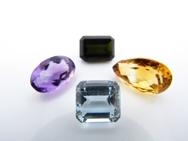 A collection of four unmounted gemstones, untested, comprising: a pear-shaped citrine, an oval