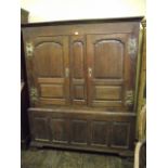 An 18th century oak livery cupboard, the upper section enclosed by a pair of fielded stepped and