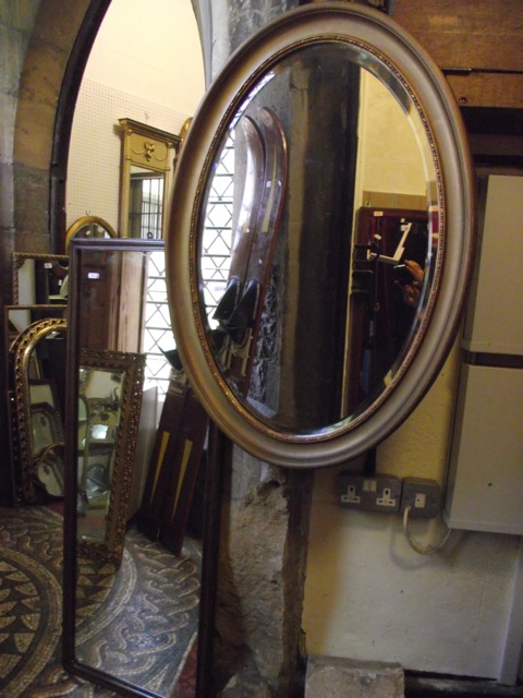 An Edwardian gilt frame wall mirror of oval form with bevelled edge plate and moulded surround,