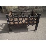 A small old English style cast iron fire basket with portcullis style frieze