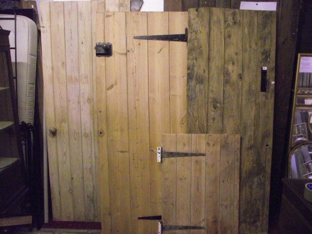 Four reclaimed ledged and braced internal tongue and groove panelled doors of varying size, three in