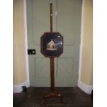 A 19th century walnut pole screen, the adjustable screen of rectangular form with canted corners and