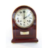 A late Edwardian mahogany mantel clock with arched case with string inlay detail, the silvered