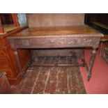 A Victorian oak writing table of rectangular form, the carved frieze with face mask lion and