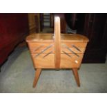 A walnut veneered floorstanding and portable sewing/workbox, the hinged twin lid with concertina