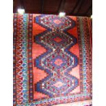 A small eastern wool rug with multi-medallion centre in shades of blue, red and green, set within