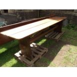 A pitch pine refectory table, the rectangular boarded top with rounded corners raised on a pair of