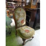 A Victorian nursing chair with floral tapestry upholstered seat and back within and shaped, carved