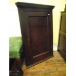 A Georgian country made stained (elm?) hanging corner cupboard enclosed by a rectangular moulded