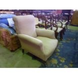 A Victorian drawing room chair with rolled back and scrolled arms on turned supports