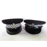 Two police caps, one bearing a badge for Cheshire Constabulary, the other for Thames Valley