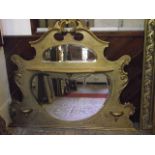 An Edwardian overmantel mirror with shaped outline, c-scroll and further detail, later gilded finish