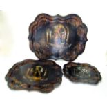 A graduated set of three mid 19th century papier mache trays set within raised and shaped borders,