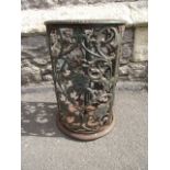 A cast iron umbrella stand of cylindrical form with pierced trailing floral detail and removable