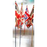 Four 20th century Union Jack flags of varying size on timber shafts