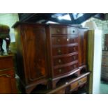 A reproduction mahogany breakfront side cupboard, partially enclosed by a pair of rectangular