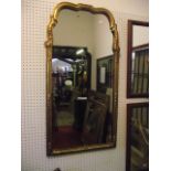A Queen Anne style wall mirror with gilded and arched moulded frame with shell and further detail,