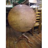 A Georgian oak snap top occasional table of circular form raised on a turned vase shaped pillar