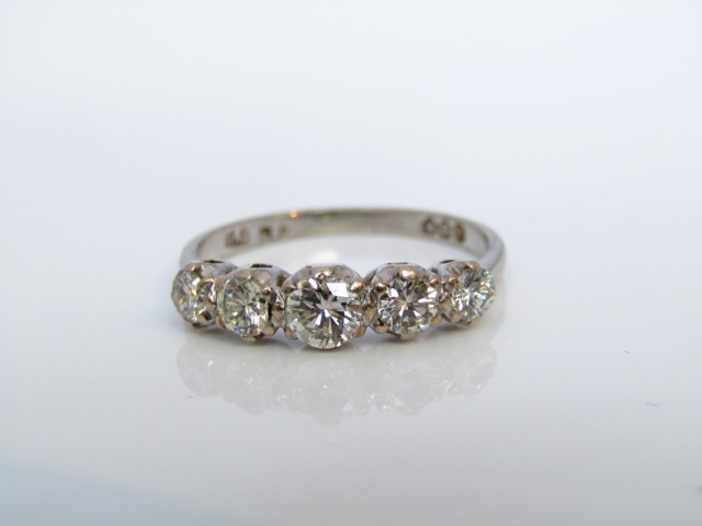 A five-stone diamond ring, set with five graduated round brilliant-cut diamonds weighing