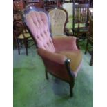 A reproduction Victorian style drawing room chair with upholstered seat and button back within a