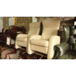 A pair of contemporary cream soft leather upholstered reclining armchairs with shaped outline