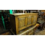 A good quality reproduction oak coffer with hinged lid and panelled frame, the front elevation