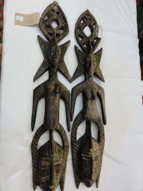 A pair of Senufo figural carved timber wall plaques, with two females figures over two masks, each