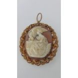A cameo brooch, the central carving depicting a lady feeding a bird, within a gilt filigree