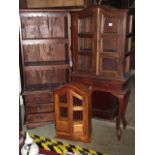 A small contemporary reproduction hardwood two sectional display cabinet with arched top over a pair