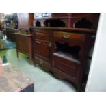 A late Victorian/Edwardian arts and crafts style mahogany sideboard, the rectangular overhanging top