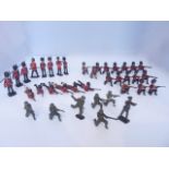 A collection of painted lead soldiers, probably by Britains, to include marching and firing