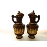 A pair of late 19th century large German relief moulded ewers and covers with decoration of
