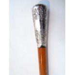 A Malacca shafted walking cane terminating in an embossed white metal knop handle of tapering form