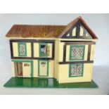 A 20th century dolls house with hinged façade over two levels with six rooms accommodating sundry