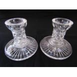 A pair of Waterford clear cut crystal candlesticks with star cross cut borders and star cut bases,