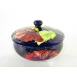 A Moorcroft dark blue ground powder bowl and cover with pink hibiscus decoration and impressed