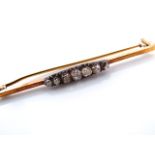 A Victorian diamond bar brooch, centred with seven graduated old-cut diamonds, in unmarked gold