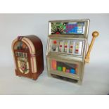 A miniature one arm bandit type slot fruit machine unit, 42 cm tall x 26 cm wide approx together