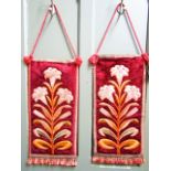 A pair of Ecclesiastical wall hangings with embroidered workmanship each depicting a lily on a