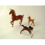 A collection of Beswick models comprising a trotting Palomino pony, a Palomino foal and a further