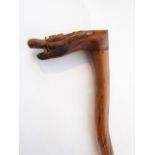 An unusual eastern hard wood walking stick of waved form terminating in a carved handle in the