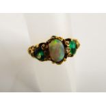 A Victorian style opal, emerald and diamond ring, centred with an oval cabochon opal, flanked to