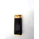 A Cartier lighter, with black lacquered finish, stamped no. C86730. the cover with black hexagons