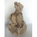 A small antique (possibly Medieval) carved limestone figure in the form of a seated gargoyle with
